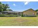 Backyard view featuring a screened pool area, lush lawn, and mature landscaping at 2914 Timber Knoll Dr, Valrico, FL 33596