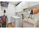 Functional laundry room with washer, dryer, sink, and storage cabinets at 2914 Timber Knoll Dr, Valrico, FL 33596