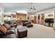 Spacious living room featuring leather sofas, a ceiling fan, and an open layout connecting to the kitchen and dining area at 2914 Timber Knoll Dr, Valrico, FL 33596
