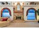 Cozy living room featuring a brick fireplace, unique decor, and arched windows with elegant drapery at 2914 Timber Knoll Dr, Valrico, FL 33596