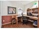 Well-lit home office with built-in wooden shelving, desk, and arched window at 2914 Timber Knoll Dr, Valrico, FL 33596
