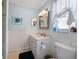 Well-lit bathroom with white fixtures, beadboard accents, and tiled flooring, creating a fresh and clean aesthetic at 2964 Catherine Dr, Clearwater, FL 33759