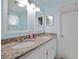 Bright bathroom featuring double sinks, granite countertops, and white cabinets, offering a clean and functional space at 2964 Catherine Dr, Clearwater, FL 33759