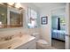 Cozy bathroom with a beadboard accent wall, featuring a sink, toilet, and a glimpse into the bedroom at 2964 Catherine Dr, Clearwater, FL 33759