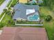 Aerial view of a home with a screened pool, well-maintained yard, and palm trees at 3168 Masters Dr, Clearwater, FL 33761