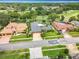 Aerial view of three residences with manicured lawns, mature trees, and a golf course in the background at 3168 Masters Dr, Clearwater, FL 33761
