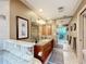 Bathroom vanity with granite countertops, sink, mirrors, and a glass block shower with tropical plants at 3168 Masters Dr, Clearwater, FL 33761