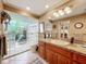 Bathroom vanity with granite countertops, sink and a glass block shower with tropical plants at 3168 Masters Dr, Clearwater, FL 33761