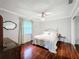 Bedroom featuring hardwood floors, ceiling fan, a large window, and dresser with a decorative mirror at 3168 Masters Dr, Clearwater, FL 33761