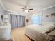 Cozy bedroom featuring a ceiling fan, closet with curtain, and large bed with decorative pillows at 3168 Masters Dr, Clearwater, FL 33761