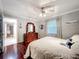 Bedroom featuring hardwood floors, ceiling fan, large window, and a dresser with a decorative mirror at 3168 Masters Dr, Clearwater, FL 33761