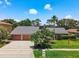Spacious home with a three-car garage, a gray roof and beautiful landscaping at 3168 Masters Dr, Clearwater, FL 33761