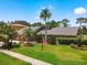 Beautiful home with well-manicured lawn, mature trees, and lush landscaping in a golf community at 3168 Masters Dr, Clearwater, FL 33761