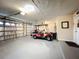 Spacious three-car garage featuring an insulated door, a golf cart, and ample storage space at 3168 Masters Dr, Clearwater, FL 33761
