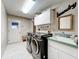 Laundry room featuring a washer and dryer, sink, cabinets, and bright overhead lighting at 3168 Masters Dr, Clearwater, FL 33761