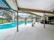 Enjoy this expansive screened-in patio, with ceiling fans, overlooking a sparkling blue pool and green lawn at 3168 Masters Dr, Clearwater, FL 33761