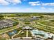 Aerial view of the community featuring lush landscaping, roundabout, pool, clubhouse, playground, and surrounding neighborhood at 31779 Asbury Ave, Wesley Chapel, FL 33545