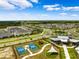 Aerial view of an active community with tennis courts, playground, and common areas at 31779 Asbury Ave, Wesley Chapel, FL 33545