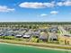 Aerial view showcases a community with homes alongside a lake and tree lined yards at 31779 Asbury Ave, Wesley Chapel, FL 33545