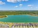 Aerial view of lakefront homes within the community with neighborhood streets, lush trees and blue sky at 31779 Asbury Ave, Wesley Chapel, FL 33545