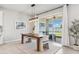 Bright dining area with a wood table, stylish light fixture, and sliding glass doors to the patio at 31779 Asbury Ave, Wesley Chapel, FL 33545