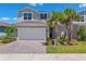 Charming two-story home features a two-car garage, brick driveway, and well-maintained landscaping at 31779 Asbury Ave, Wesley Chapel, FL 33545