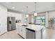 Stylish kitchen with white countertops, stainless steel appliances, and views of the dining area and lake at 31779 Asbury Ave, Wesley Chapel, FL 33545