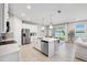 Bright kitchen area with white cabinets, stainless appliances, island, and a view of the lake from the window at 31779 Asbury Ave, Wesley Chapel, FL 33545