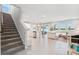 Open-concept living area with staircase, flowing to the kitchen, dining, and comfortable lounge space at 31779 Asbury Ave, Wesley Chapel, FL 33545