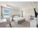 Serene main bedroom with tray ceilings, two windows with a lake view, and neutral decor at 31779 Asbury Ave, Wesley Chapel, FL 33545