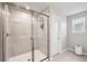 Modern tiled shower with glass doors in neutral bathroom at 31779 Asbury Ave, Wesley Chapel, FL 33545