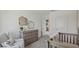 Comfortable Bedroom with a crib, dresser/changing table, and cozy chair, designed with soft tones to create a serene atmosphere at 32730 Winterwood Boulevard Blvd, Wesley Chapel, FL 33543