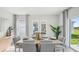 Stylish dining area with seating for six, accented by natural light and a view of the outdoors at 32730 Winterwood Boulevard Blvd, Wesley Chapel, FL 33543