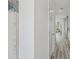 Bright hallway with gray wood-look flooring, leading into a living space, showcasing a modern and open floor plan at 32730 Winterwood Boulevard Blvd, Wesley Chapel, FL 33543