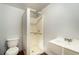 This bathroom has a small shower stall, toilet and sink with wood-like flooring at 3407 Cason Rd, Plant City, FL 33566