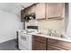 This kitchen contains white appliances and a stainless steel sink with brown cabinets at 3407 Cason Rd, Plant City, FL 33566