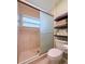 Bathroom showcasing a glass-enclosed shower, modern toilet, and practical shelving for towel storage at 3408 90Th N Ter, Pinellas Park, FL 33782