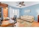 A cozy bedroom featuring a light blue wall, a ceiling fan, and natural light from the window at 3408 90Th N Ter, Pinellas Park, FL 33782