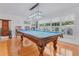 Bright game room featuring a pool table, large window with shutters and a rack with pool accessories at 3408 90Th N Ter, Pinellas Park, FL 33782