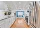 Modern kitchen featuring stainless appliances, granite countertops, and white cabinets with wood flooring at 3408 90Th N Ter, Pinellas Park, FL 33782