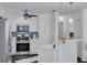 Bright kitchen featuring white cabinets, stainless steel appliances, and a breakfast bar at 3516 Casablanca Ave, St Pete Beach, FL 33706