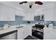 Modern kitchen featuring white cabinets, stainless steel appliances, blue tile backsplash and quartz countertops at 3516 Casablanca Ave, St Pete Beach, FL 33706