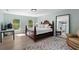 A bright bedroom with hardwood floors, large windows, and a decorative mirror adding space to the room at 3601 W San Juan St, Tampa, FL 33629