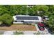 Aerial view of a single-story home with a metal roof, solar panels, an accessible ramp, and a well-lit driveway at 38351 7Th Ave, Zephyrhills, FL 33542