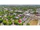 Aerial view of a neighborhood with mature trees, commercial buildings, and residential homes at 38351 7Th Ave, Zephyrhills, FL 33542