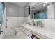 A functional bathroom includes white tiled walls, vanity with storage and large mirror at 38351 7Th Ave, Zephyrhills, FL 33542
