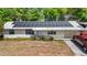 Single-story home featuring a metal roof with solar panels, an accessible ramp, and a well-lit driveway at 38351 7Th Ave, Zephyrhills, FL 33542