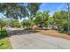 House with solar panels, palm trees, extra storage, driveway, and foliage at 38351 7Th Ave, Zephyrhills, FL 33542