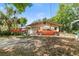 Exterior view of a house with an orange car and red truck in the driveway on a sunny day at 38351 7Th Ave, Zephyrhills, FL 33542