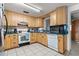 Functional kitchen with wooden cabinets, tile flooring, and essential appliances at 38351 7Th Ave, Zephyrhills, FL 33542